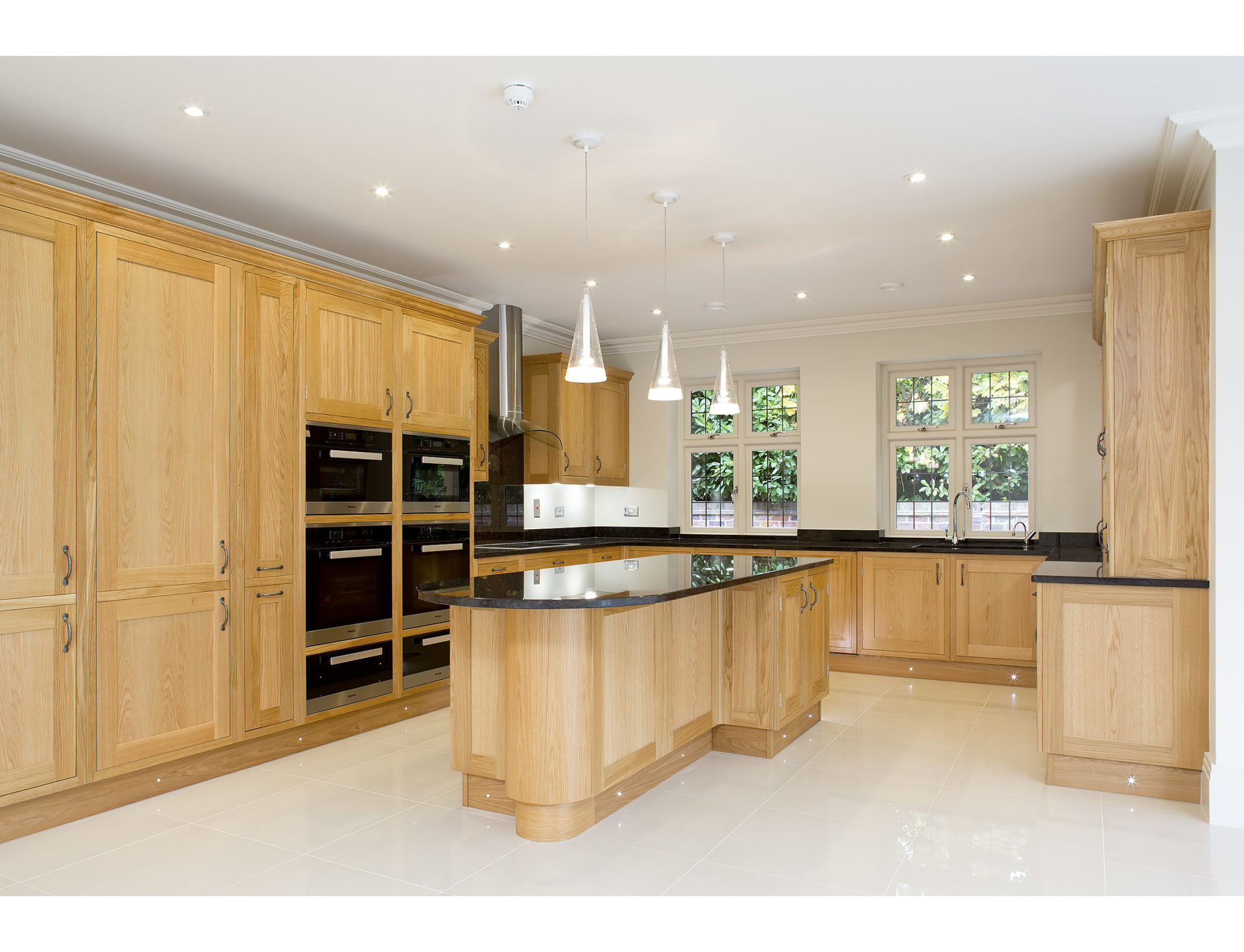 Large kitchen with wooden cupboards and back worktops