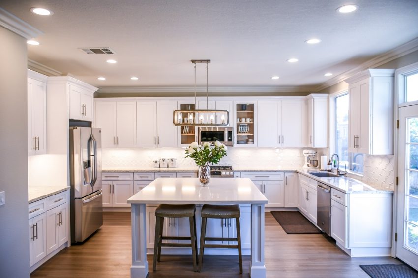 Modern kitchen with an island, white cabinets and marble worktops