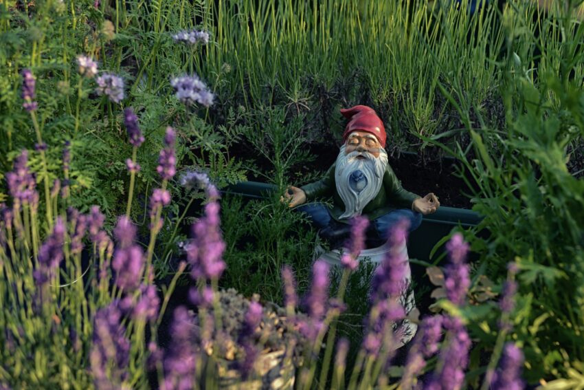 Gnome sat on a bucket by the pond